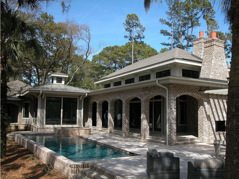 Diseño de piscinas y jacuzzis alargados clásicos de tamaño medio rectangulares en patio trasero con losas de hormigón