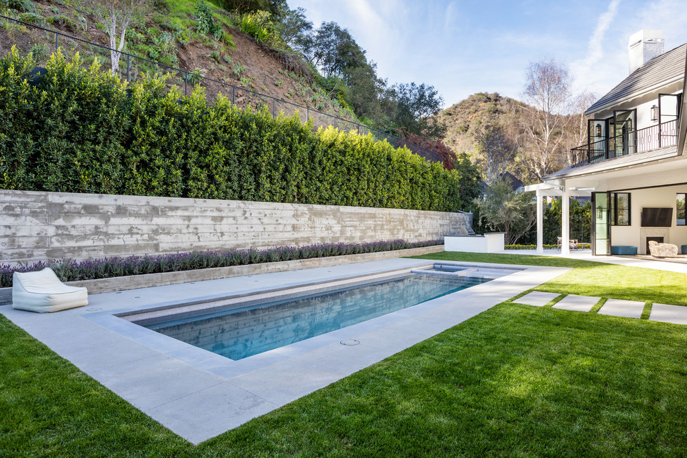 Klassischer Pool hinter dem Haus in rechteckiger Form mit Betonplatten in Los Angeles