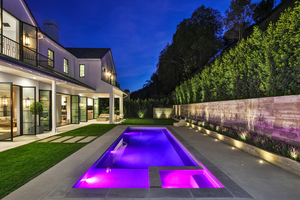 Klassischer Pool hinter dem Haus in rechteckiger Form mit Betonplatten in Los Angeles