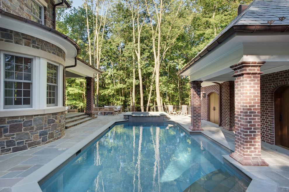 Ejemplo de casa de la piscina y piscina natural clásica de tamaño medio a medida en patio lateral con adoquines de piedra natural