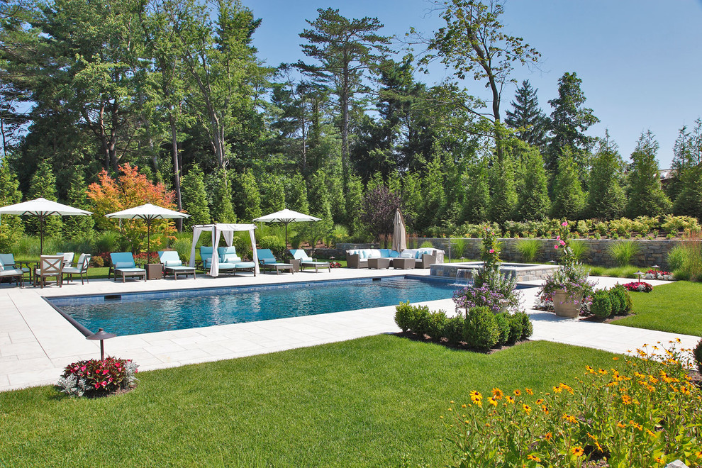 Foto de piscinas y jacuzzis naturales clásicos grandes rectangulares en patio trasero con adoquines de hormigón