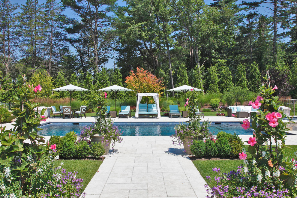 На фото: большой прямоугольный, естественный бассейн на заднем дворе в классическом стиле с джакузи и мощением тротуарной плиткой с