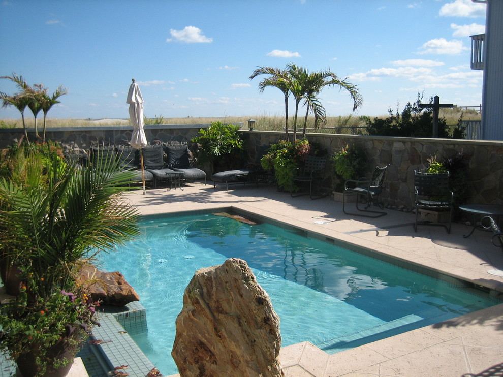 Esempio di un'ampia piscina naturale etnica rettangolare nel cortile laterale con una dépendance a bordo piscina e pavimentazioni in pietra naturale