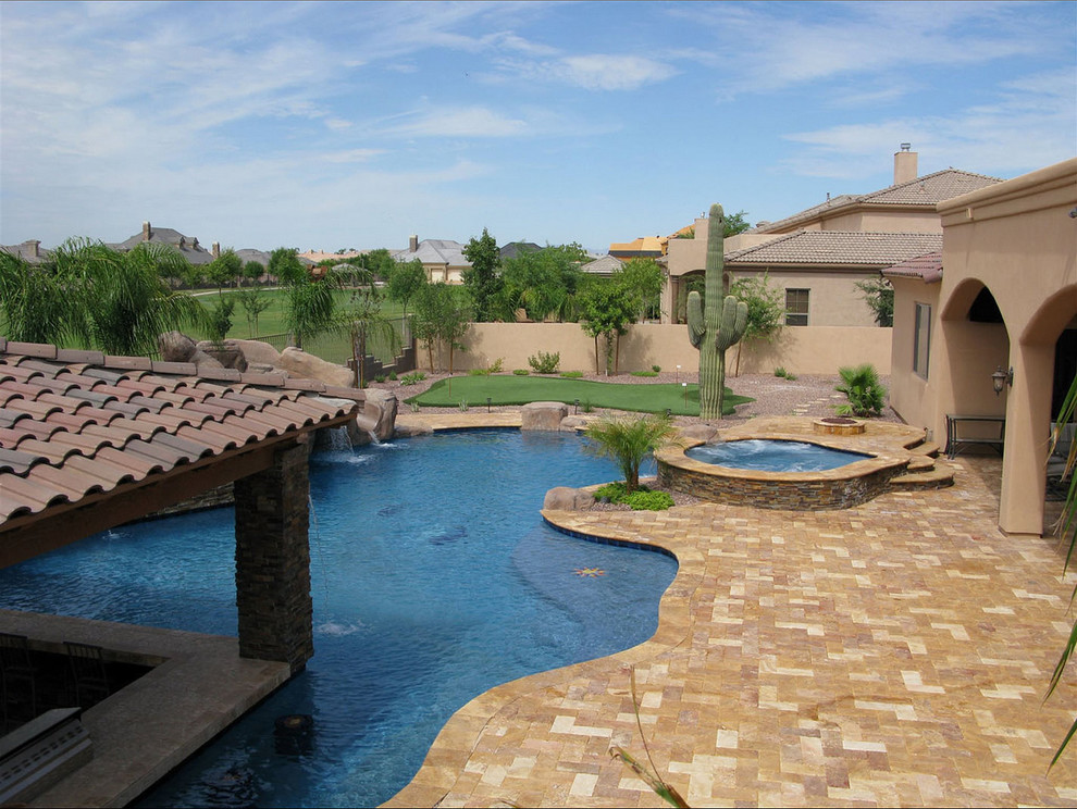 Immagine di un'ampia piscina stile rurale dietro casa con pavimentazioni in pietra naturale