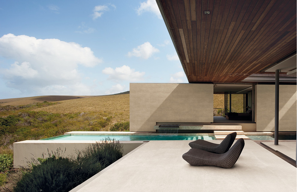 Inspiration pour une piscine à débordement minimaliste rectangle avec du carrelage.