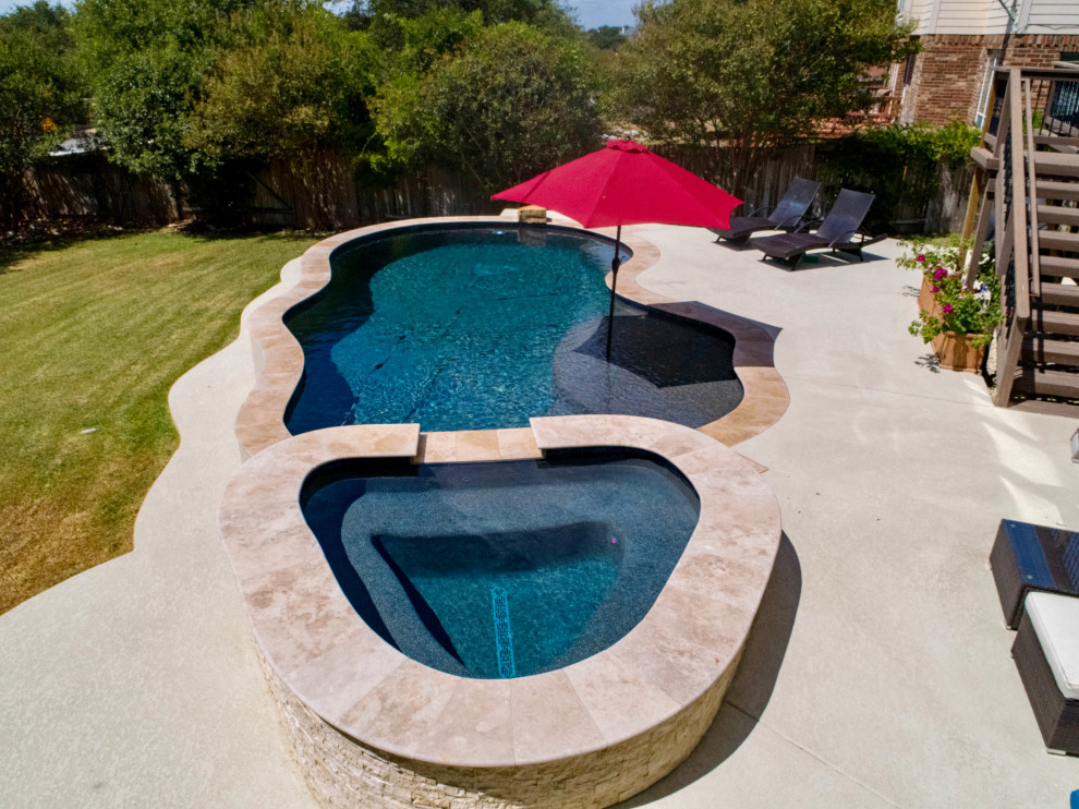 Design ideas for a medium sized traditional back custom shaped swimming pool in Austin with concrete slabs.