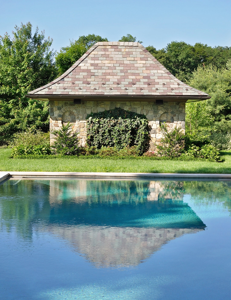 Imagen de piscina con fuente alargada de estilo americano grande rectangular en patio trasero con adoquines de piedra natural