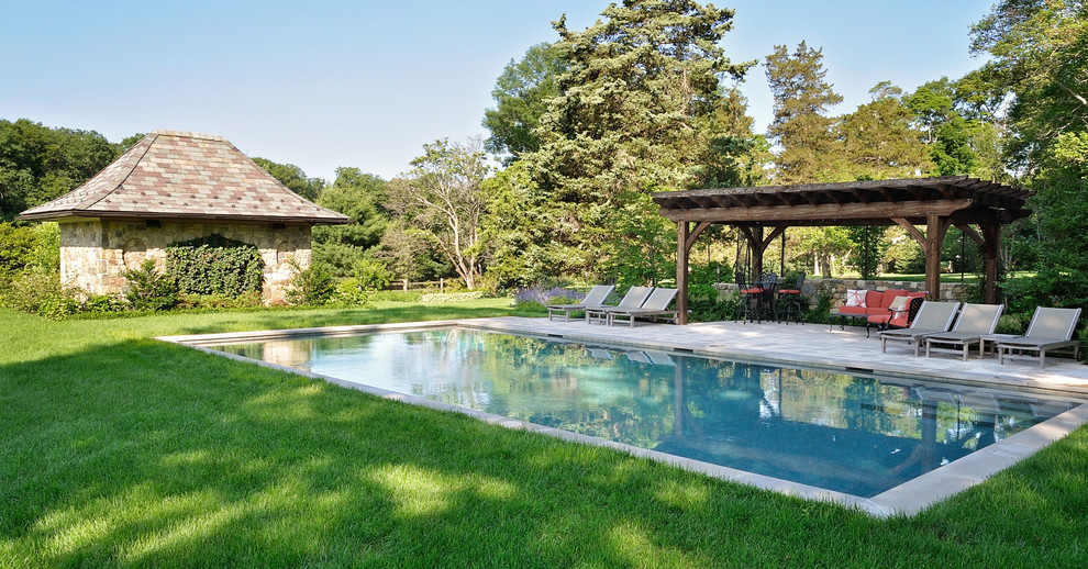 Foto de piscina con fuente alargada de estilo americano grande rectangular en patio trasero con adoquines de hormigón