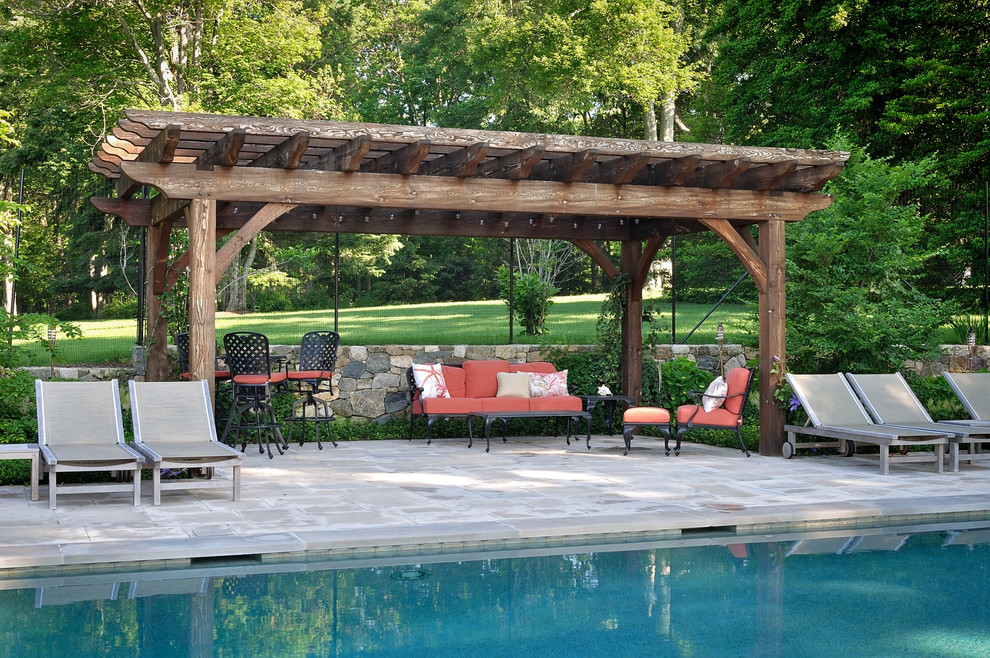 Idee per una grande piscina monocorsia stile americano rettangolare dietro casa con pavimentazioni in pietra naturale e fontane