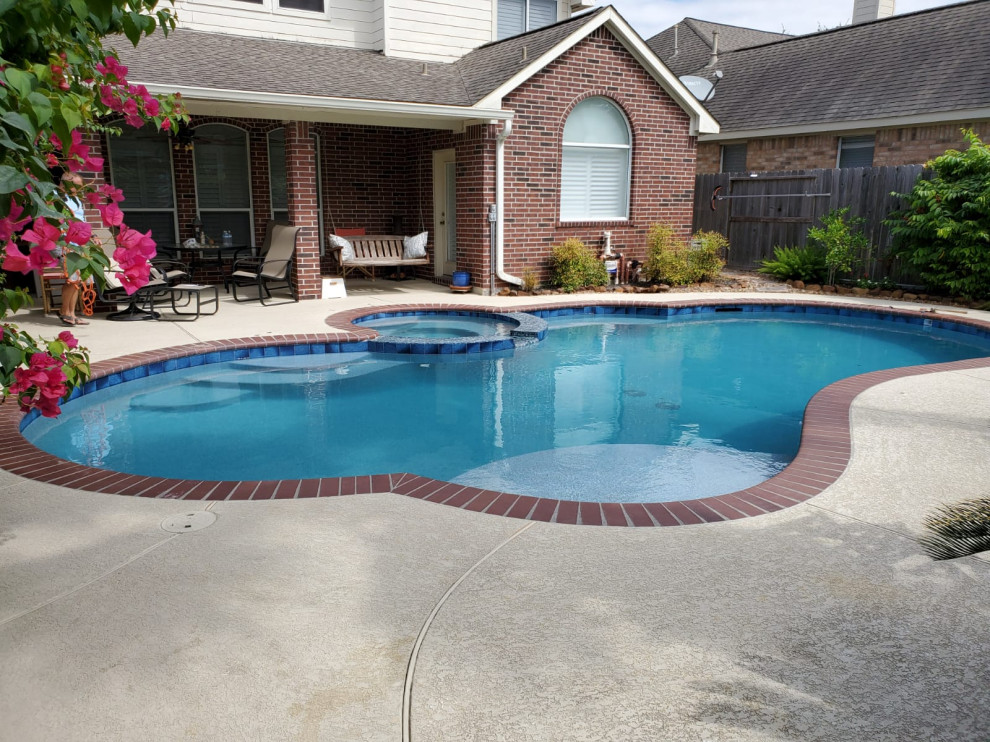 Diseño de piscinas y jacuzzis alargados tradicionales de tamaño medio a medida en patio trasero con suelo de hormigón estampado