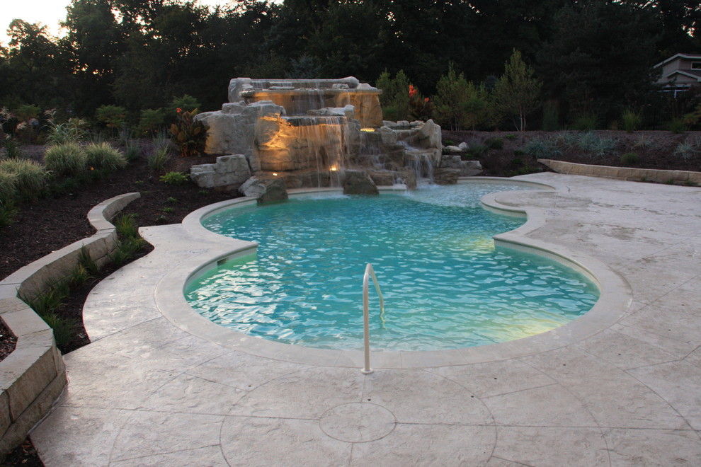 Diseño de piscina con fuente natural costera de tamaño medio a medida en patio trasero con suelo de hormigón estampado