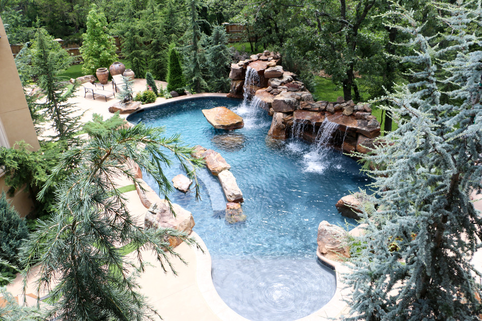 Esempio di una piscina naturale rustica personalizzata di medie dimensioni e dietro casa con fontane e lastre di cemento
