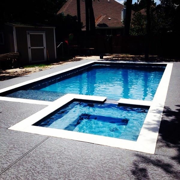 Foto di una piscina monocorsia design rettangolare di medie dimensioni e dietro casa con una vasca idromassaggio e lastre di cemento