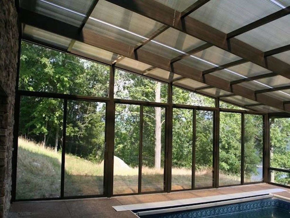 Ejemplo de piscina alargada clásica grande rectangular en patio trasero con losas de hormigón