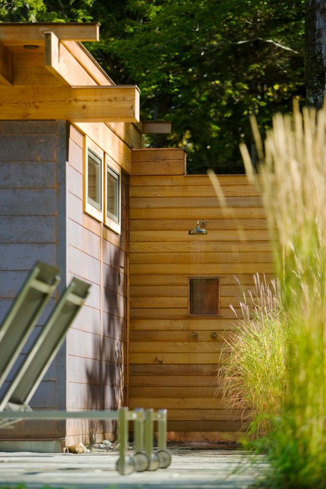Ejemplo de casa de la piscina y piscina alargada minimalista grande rectangular en patio trasero con adoquines de piedra natural