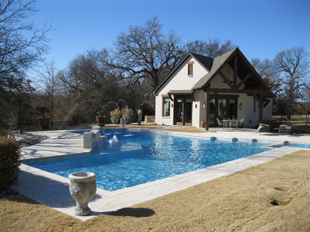 Idee per una piscina design a "L" dietro casa con una dépendance a bordo piscina e pavimentazioni in pietra naturale