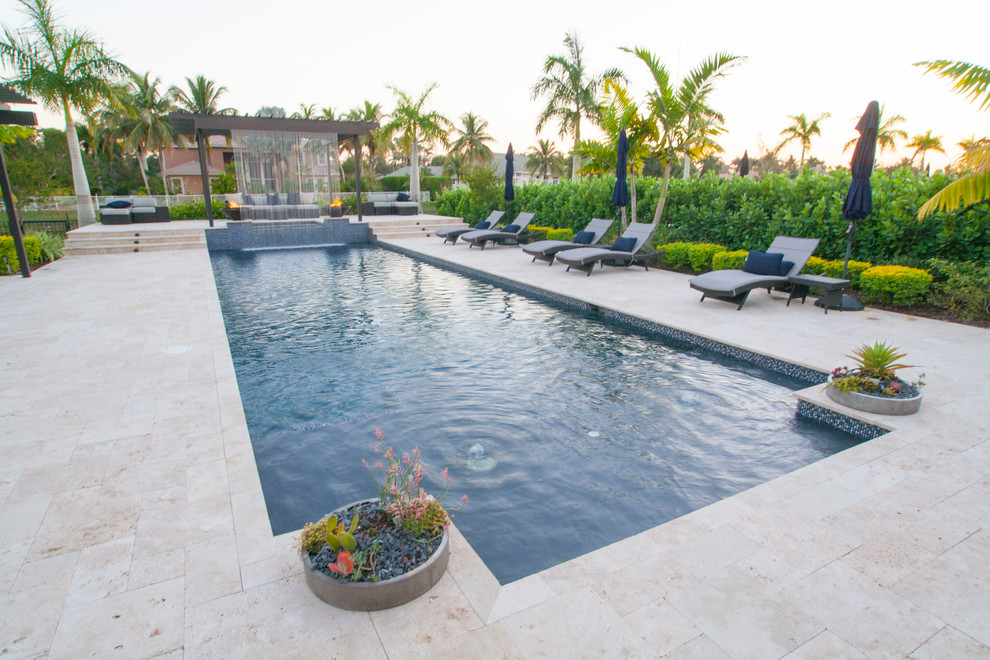Large beach style backyard stone and custom-shaped lap pool fountain photo in Miami