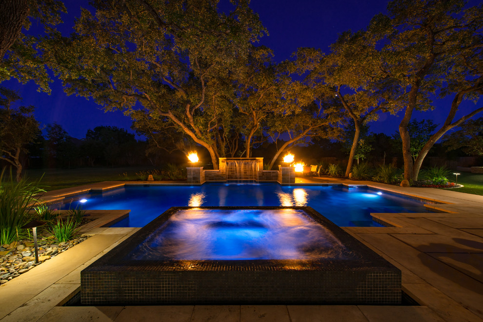 Foto di una grande piscina mediterranea personalizzata dietro casa con una vasca idromassaggio e pavimentazioni in cemento