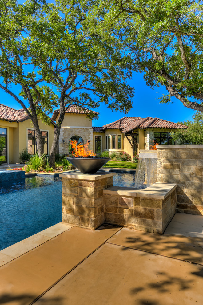Photo of a large mediterranean back custom shaped hot tub in Austin with concrete paving.