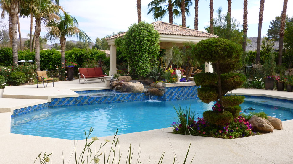 Foto de piscinas y jacuzzis alargados clásicos grandes a medida en patio trasero con adoquines de hormigón