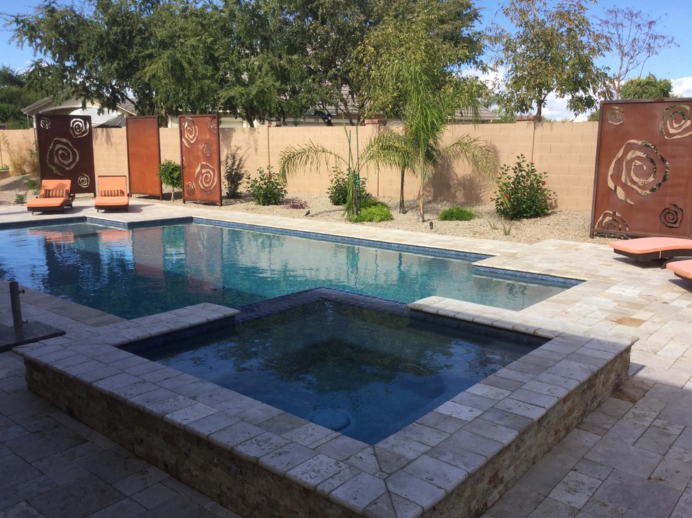 Esempio di una piscina monocorsia moderna rettangolare di medie dimensioni e dietro casa con una vasca idromassaggio e pavimentazioni in pietra naturale