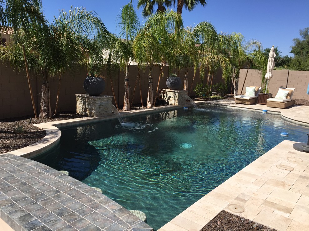 Foto di una grande piscina monocorsia classica rettangolare dietro casa con fontane e pavimentazioni in pietra naturale