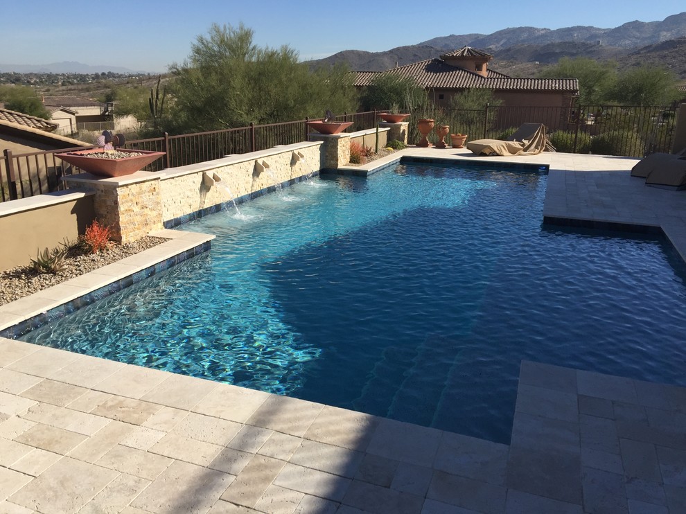 Ejemplo de piscina con fuente alargada clásica renovada de tamaño medio a medida en patio trasero con adoquines de piedra natural