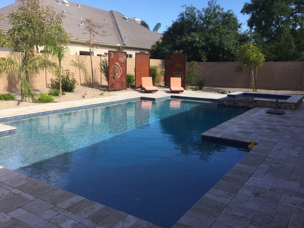 Diseño de piscinas y jacuzzis alargados modernos de tamaño medio a medida en patio trasero con adoquines de piedra natural