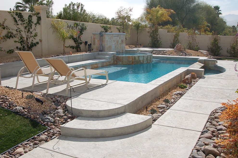Mittelgroßer Moderner Infinity-Pool hinter dem Haus in individueller Form mit Stempelbeton und Wasserspiel in Sonstige