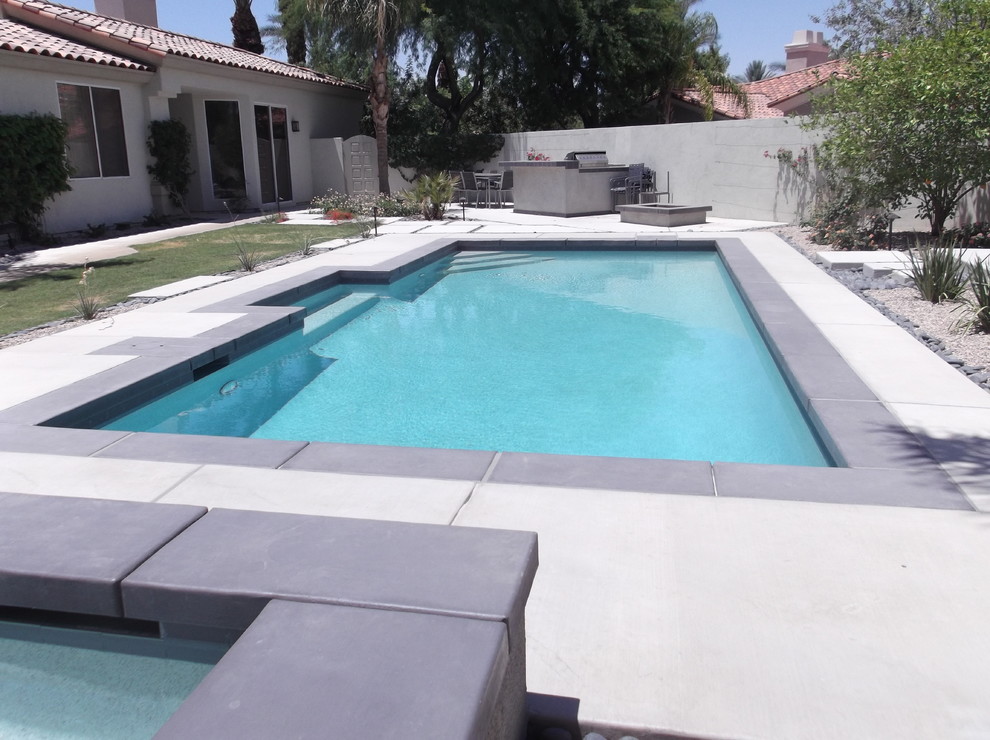 Foto de piscina alargada moderna grande rectangular en patio lateral con losas de hormigón