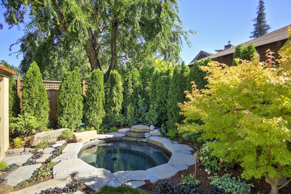 Foto på en stor vintage pool på baksidan av huset, med en fontän och naturstensplattor
