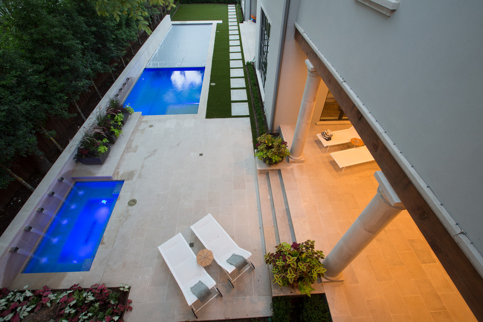 Diseño de piscina con fuente alargada tradicional renovada de tamaño medio rectangular en patio trasero con adoquines de piedra natural