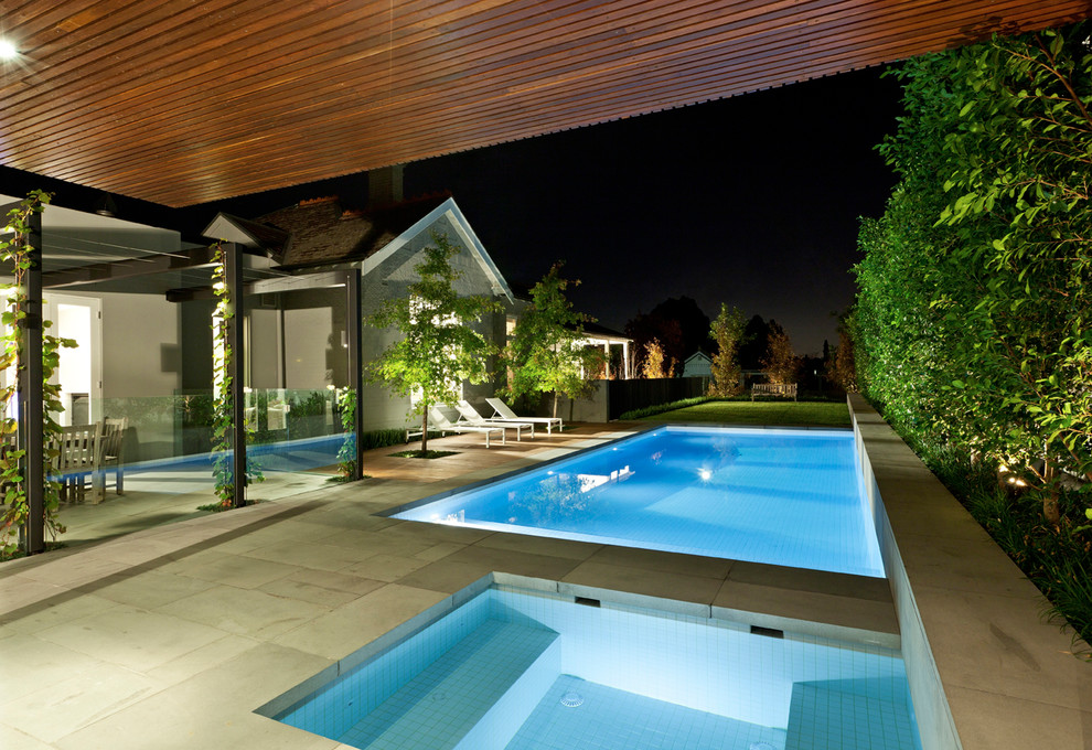 На фото: спортивный, прямоугольный бассейн в стиле модернизм с покрытием из каменной брусчатки с