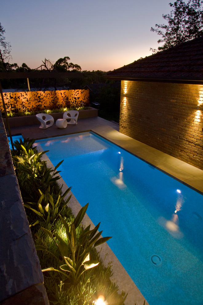 Foto di una piscina monocorsia contemporanea rettangolare di medie dimensioni e dietro casa con fontane e pavimentazioni in pietra naturale