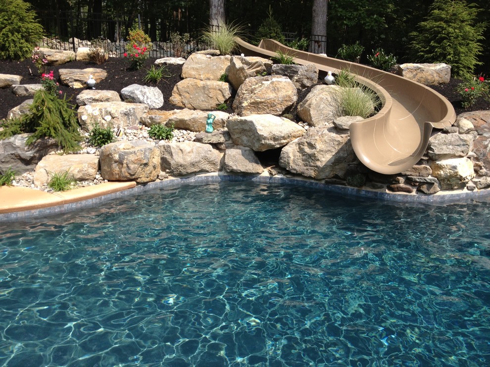 Inspiration pour une piscine naturelle et arrière traditionnelle sur mesure avec une terrasse en bois et un bain bouillonnant.