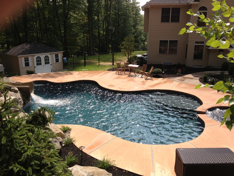 Diseño de piscinas y jacuzzis naturales clásicos a medida en patio trasero con entablado