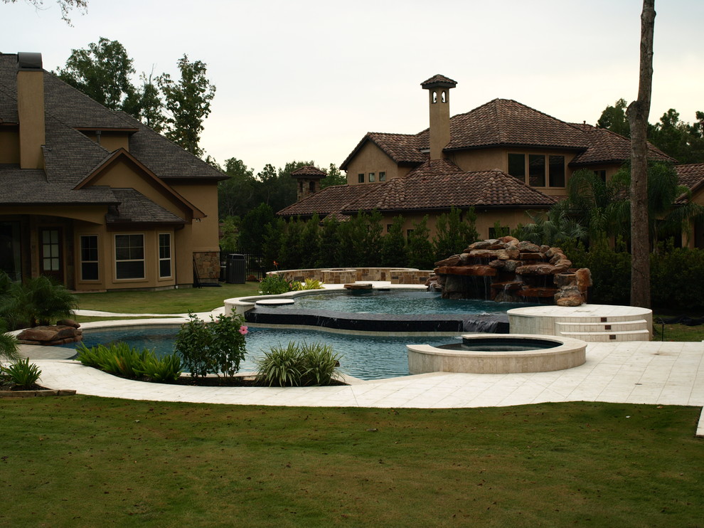 Пример оригинального дизайна: огромный бассейн на заднем дворе в стиле фьюжн