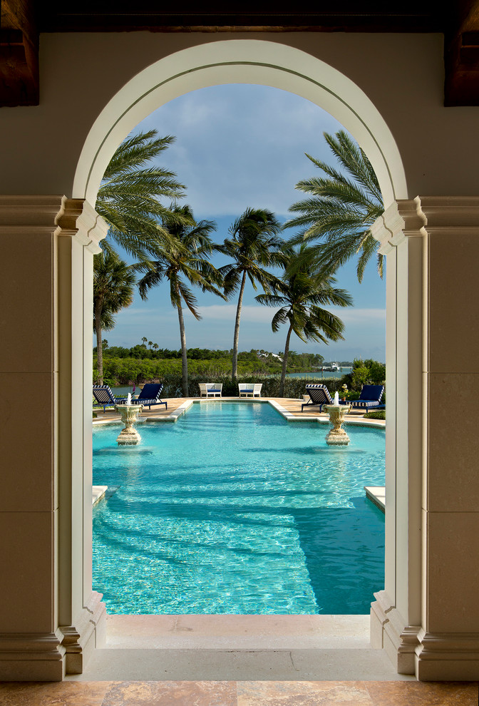 マイアミにある巨大な地中海スタイルのおしゃれなプール (噴水、天然石敷き) の写真