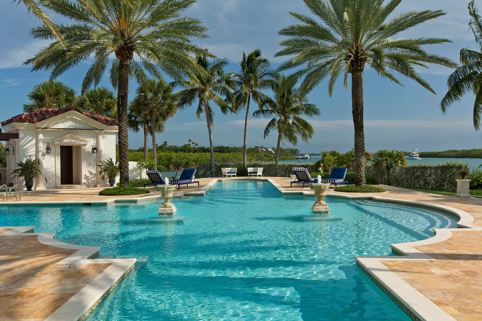 Diseño de piscina alargada mediterránea extra grande a medida en patio trasero con adoquines de piedra natural