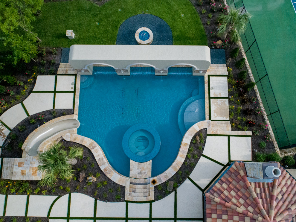 Réalisation d'une grande piscine à débordement et arrière minimaliste sur mesure avec un toboggan et des pavés en pierre naturelle.