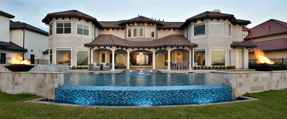 Diseño de piscinas y jacuzzis infinitos clásicos renovados grandes a medida en patio trasero con adoquines de piedra natural
