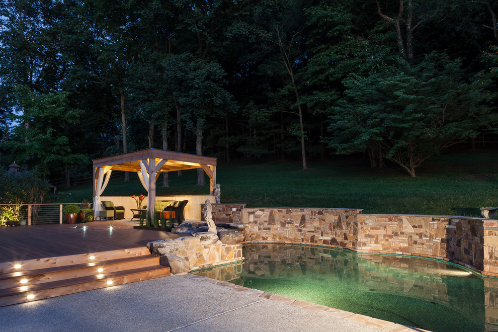 Foto de piscina con fuente elevada de estilo americano grande a medida en patio trasero con entablado