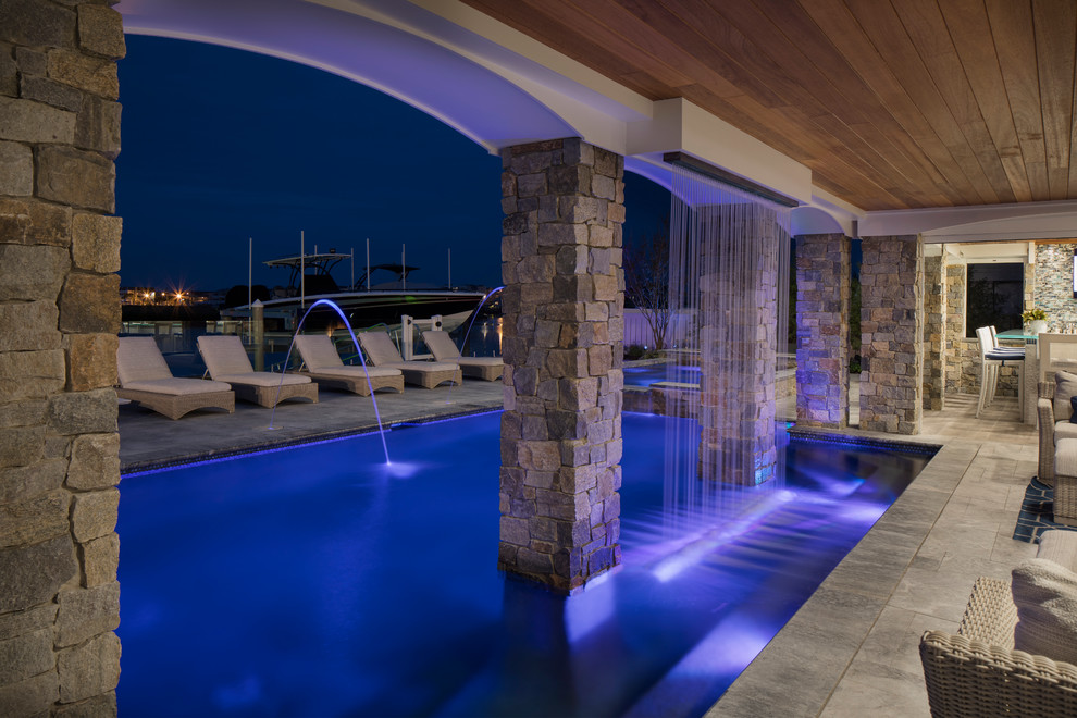 Immagine di una grande piscina monocorsia costiera personalizzata dietro casa con una vasca idromassaggio e pavimentazioni in cemento