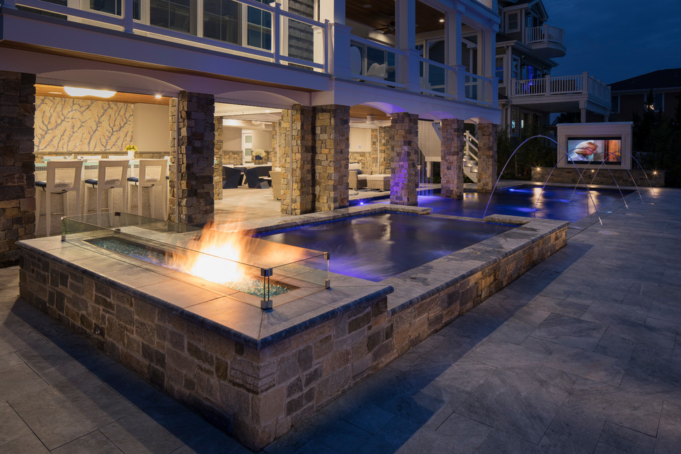 Idee per una grande piscina monocorsia stile marinaro personalizzata dietro casa con una vasca idromassaggio e pavimentazioni in cemento