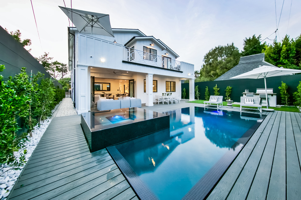 Foto di una piscina minimalista rettangolare di medie dimensioni e dietro casa con una vasca idromassaggio e pedane