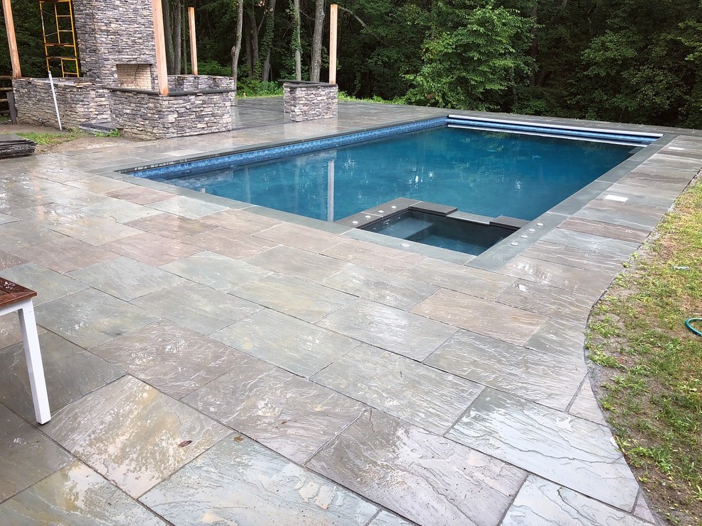 Diseño de piscinas y jacuzzis naturales actuales rectangulares en patio trasero con adoquines de piedra natural