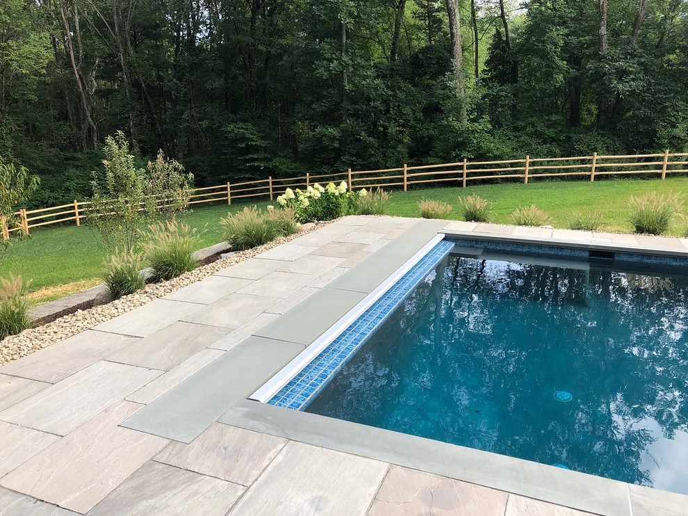 Moderner Schwimmteich hinter dem Haus in rechteckiger Form mit Pool-Gartenbau und Natursteinplatten in New York
