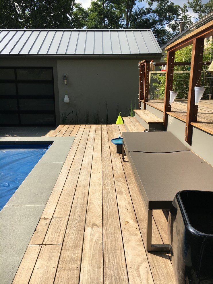 Inspiration for a medium sized modern back rectangular lengths swimming pool in New York with a pool house and decking.
