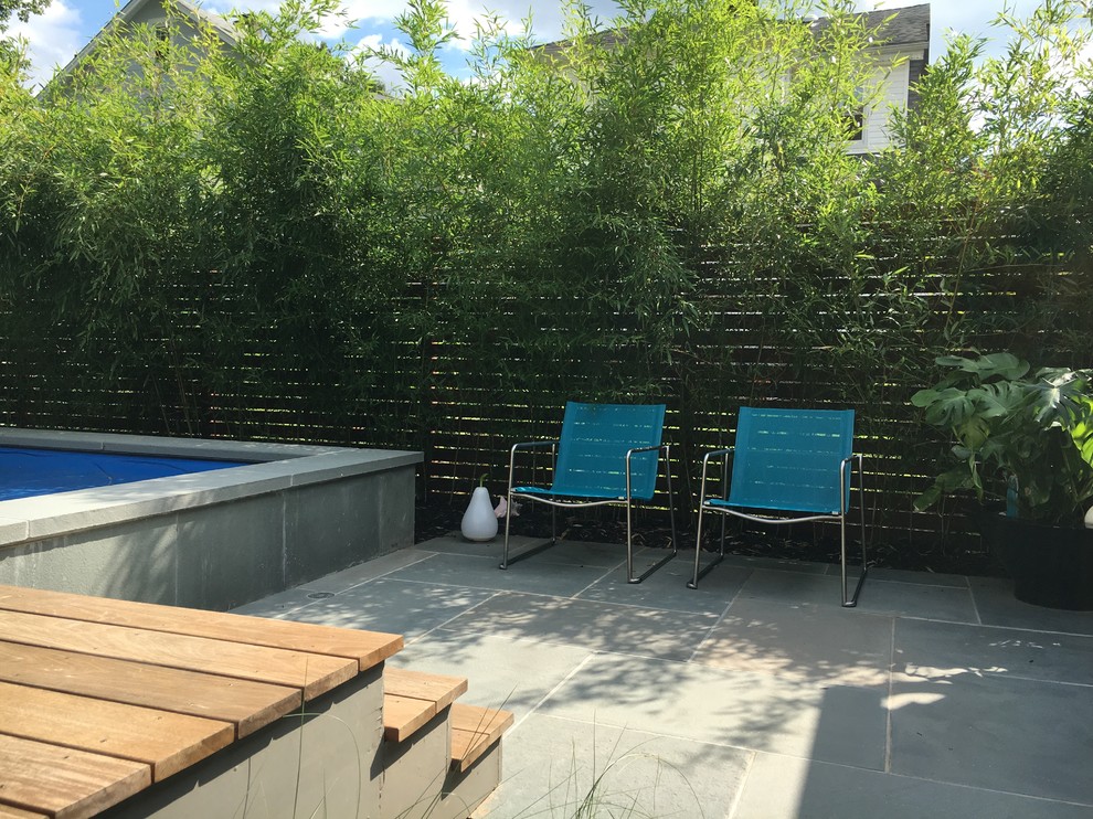 Exemple d'une grande piscine hors-sol moderne sur mesure avec une cour, des pavés en pierre naturelle et un point d'eau.