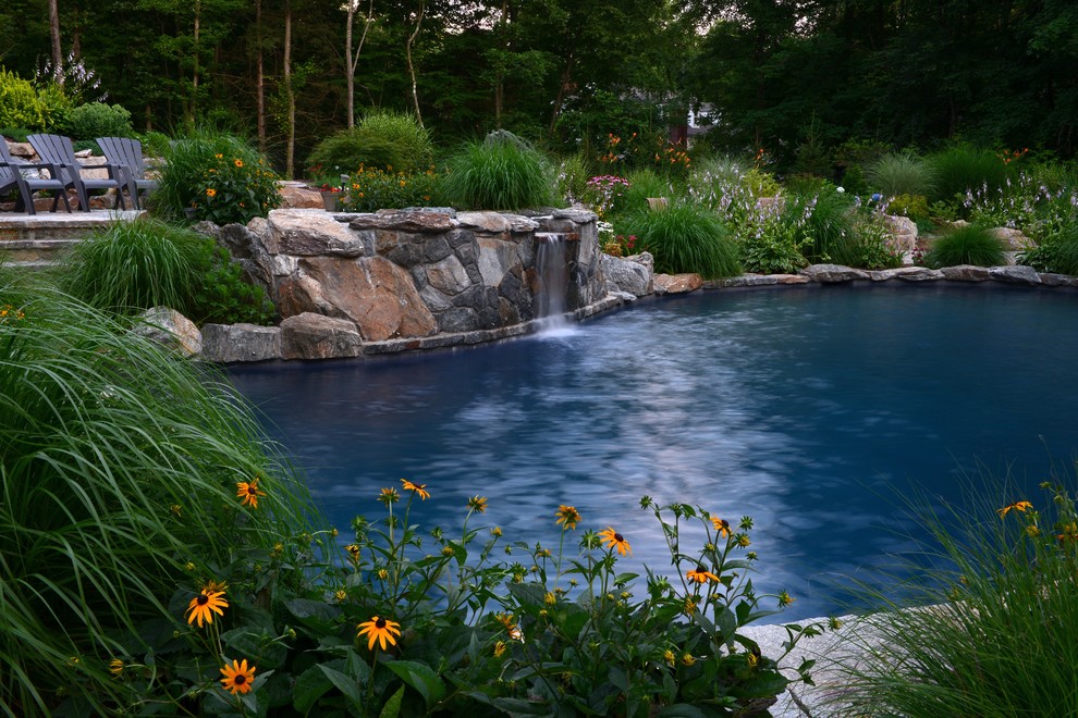 Diseño de piscina con fuente natural rústica de tamaño medio a medida en patio trasero con adoquines de piedra natural